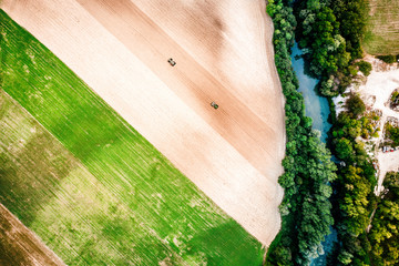 Aerial top view photo from flying drone of a land with sown green fields in countryside in spring...