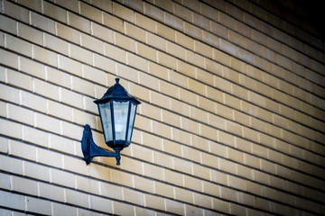 Street lamp hanging on a brick wall.