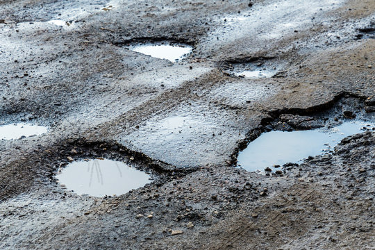 The hole in the road. Asphalt with defects. Dangerous encounter on the road.