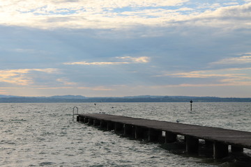 Obraz premium The sun breaking through the clouds over lake Garda Italy