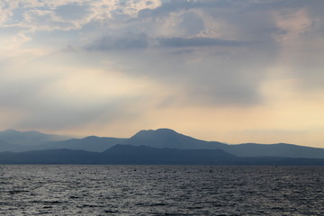 The sun breaking through the clouds over lake Garda Italy