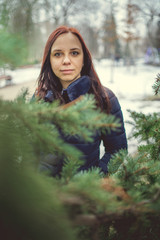 Naklejka premium Girl walking in the fresh air in winter. Cheerful and beautiful woman posing on the street, in the city Park. Concept: a walk in the fresh air, the guarantee of health and good mood