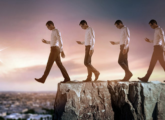 conceptual portrait of a young businessman falling down from the cliff