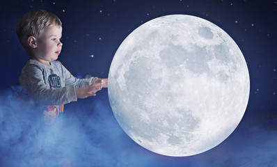 Art portrait of a cute little boy holding a moon