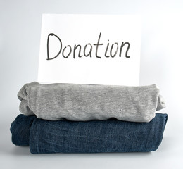 folded clothes and a white sheet of paper with the inscription donation