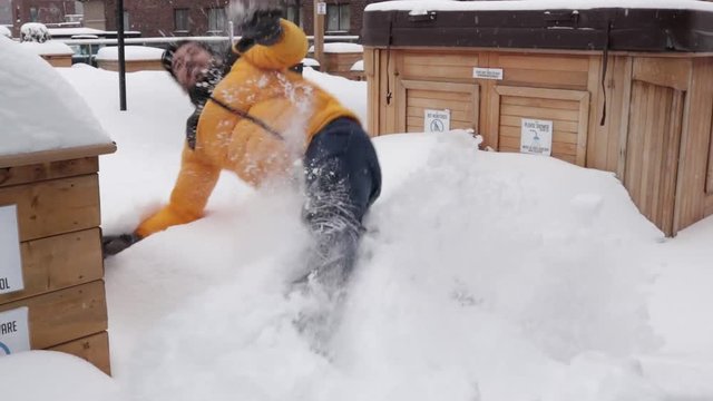 Man in winter clothes playing in the snow. Man Snow angel. Man Playing and throwing snow up in the air.
