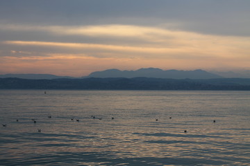 The sun breaking through the clouds over lake Garda Italy