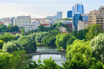 Beautiful view from the height of the spring city center with diverse architecture and a park along the city river.