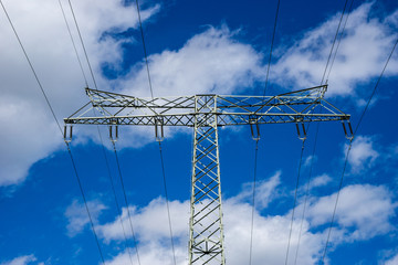 power lines on blue sky and high voltage power pylon