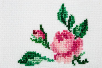 Naklejka na ściany i meble Rose flower embroidered with a cross on textile canvas