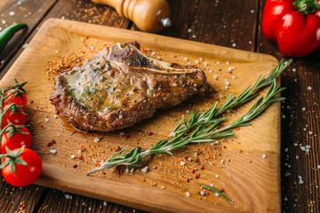 Grilled steak on the bone and tomatoes on a branch