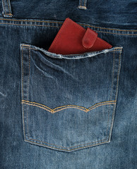Brown leather wallet in the back pocket of blue jeans