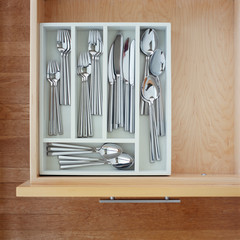 Clean silverware utensils in kitchen drawer. Neat, tidy, organized home kitchen storage.