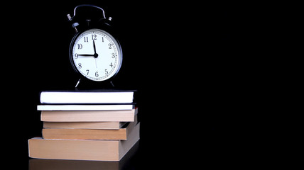 Back to school concept with alarm clock, books, apple and pencils. Note paper, alarm clock, pen and pencil.