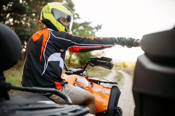 Two atv riders hits fists for good luck, back view