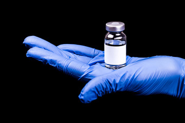 Doctor in sterile gloves holding a medical ampoule on black background
