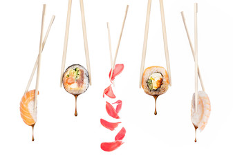 Set of different sushi rolls with chopsticks on a white background