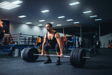 Obraz na płótnie Canvas Male powerlifter starting deadlift barbell in gym