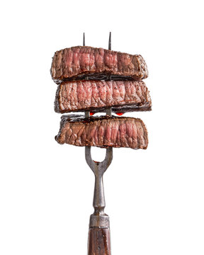 Slices of beef steak on vintage fork isolated on white