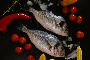 Fish seafood dorado, raw food on black background,  diet.