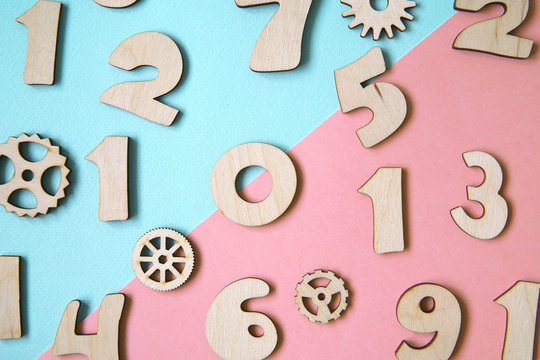 Wooden numbers on pastel colored background.