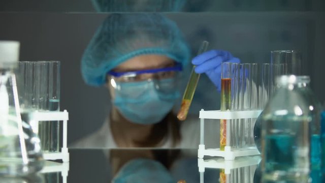 Lab worker analyzing meat sample in tube and adding chemical agent, parasites