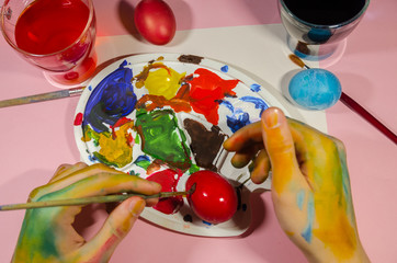 colored hands painting easter eggs