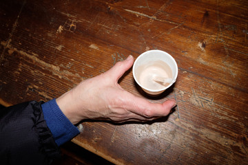 Une main prends un café dans un gobelet en plastique