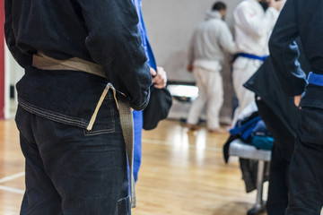 Close up on midsection of brazilian jiu jitsu BJJ fighter holding his belt while waiting to compete at the tournament