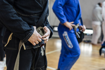 Close up on midsection of brazilian jiu jitsu BJJ fighter holding his belt while waiting to compete at the tournament
