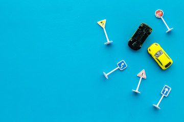 Car insurance concept with car toys on blue background top view copyspace