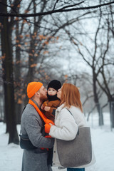 Dad mom and baby in the park in winter