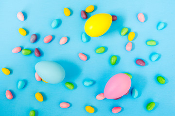 Fototapeta na wymiar Easter decoration eggs and candy on blue background. Easter background