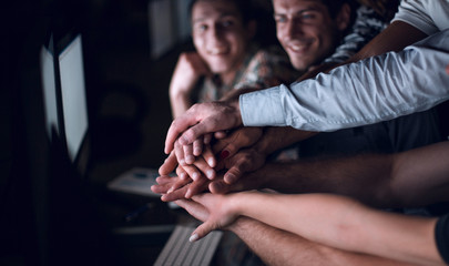 close up.young active office workers hold their hands together