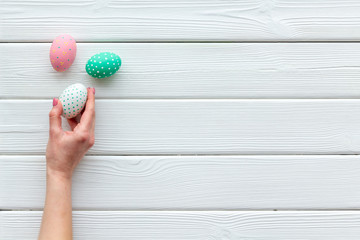 eggs with colorful paint for easter tradition on white wooden background top view mockup