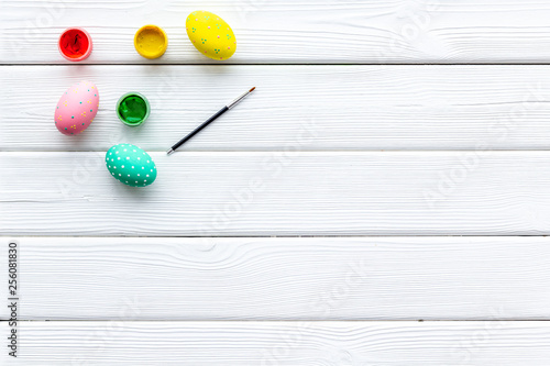 paint eggs for Easter celebration on white wooden background top view mock up