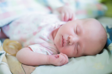 small child is smiling in his sleep. newborn girl sleeps sweetly in a crib.
