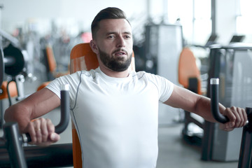 young man does weight training in the gym