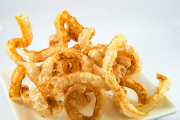 fried crispy pork scratching on white plate / pork snack crackling asian food