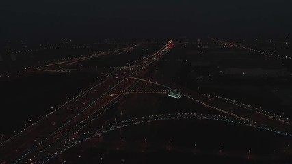 Aerial top view of highway interchange at night. Aerial top view of road junction from above, automobile traffic and jam of many cars, useful for engineering, industrial, transportation concept