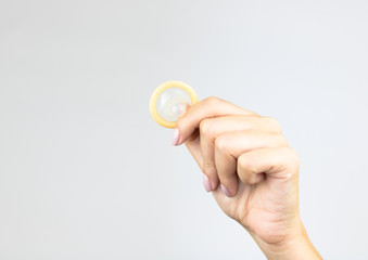 Woman's hands holding male condom.