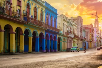 Foto auf Leinwand Oldtimer und farbenfrohe Gebäude in Havanna bei Sonnenuntergang © kmiragaya