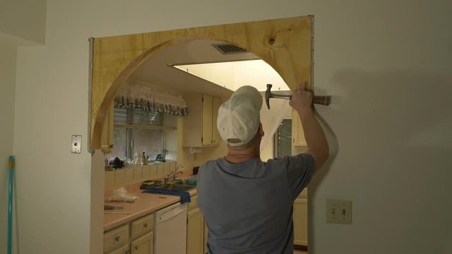 A carpenter framing an arch on a remodel job