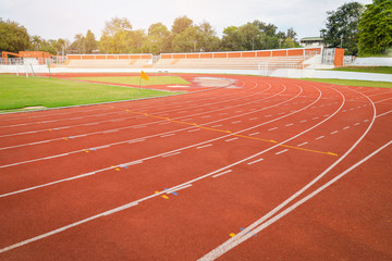 Athletics Track Run / Red running track in stadium with green field  with white line in sports outdoor