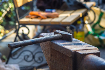 blacksmith performs the forging of hot glowing metal on the anvil