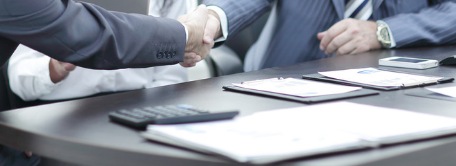handshake between colleagues in the workplace in the office