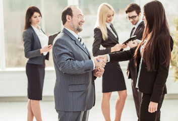 welcome handshake between lawyer and client on the background of business team