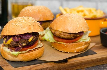 Homemade delicious three mini burgers: beef, chicken, vegan served with sauce and french fries. Homemade mini burger sliders. 