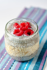 Pudding of chia seeds and oatmeal with raspberries in glass jar