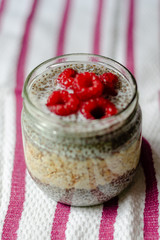 Chia seed pudding with oats and raspberries on striped background